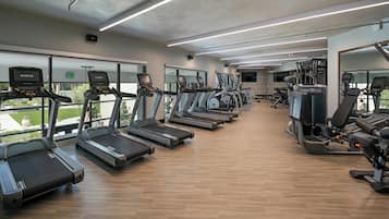 A gym with treadmills, weight machines, and exercise balls.