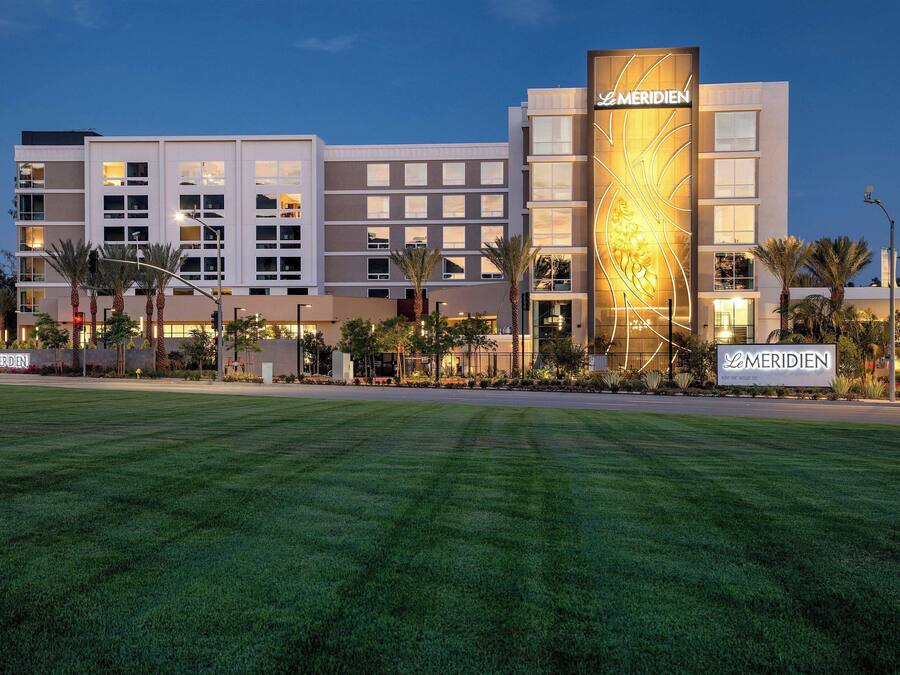 A hotel with a modern design, featuring multiple floors and a prominent sign.