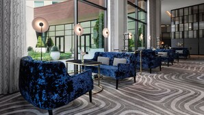 A modern lobby with blue upholstered seating, large windows, and a patterned carpet. - Le Méridien Pasadena Arcadia (Arcadia)