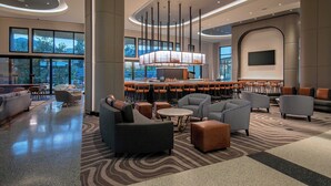 A modern lobby with seating areas, a bar, and large windows. - Le Méridien Pasadena Arcadia (Arcadia)