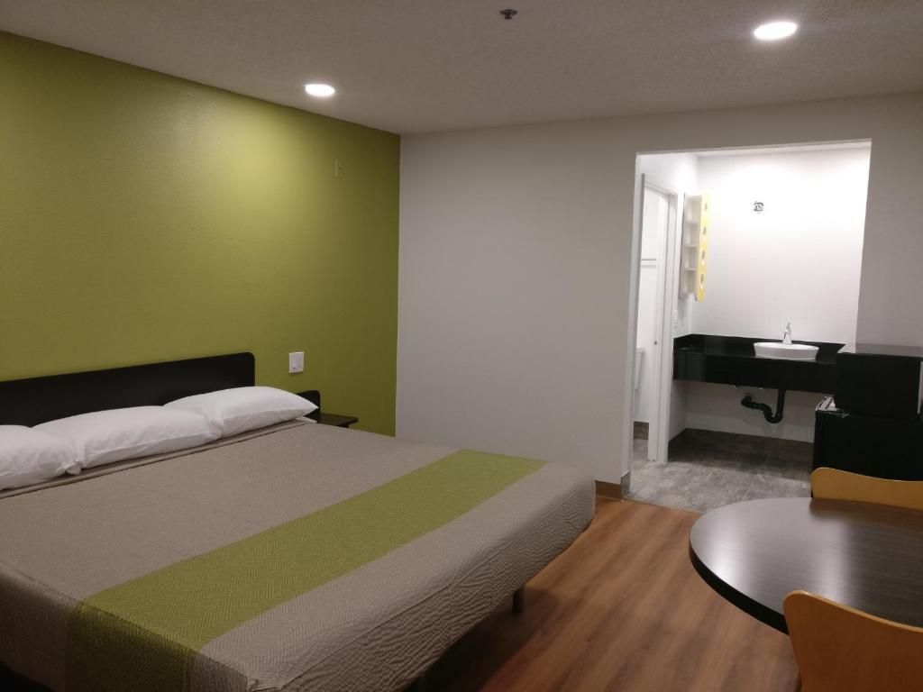 A hotel room with a bed, a desk, and a chair.