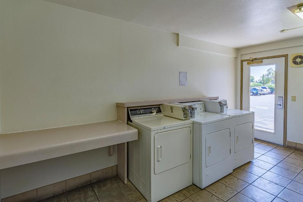 A laundry area with a washing machine, dryer, and a bench.