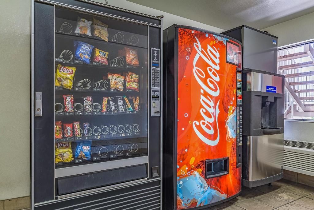 A vending machine with a Coca-Cola logo and a snack vending machine with various snacks.