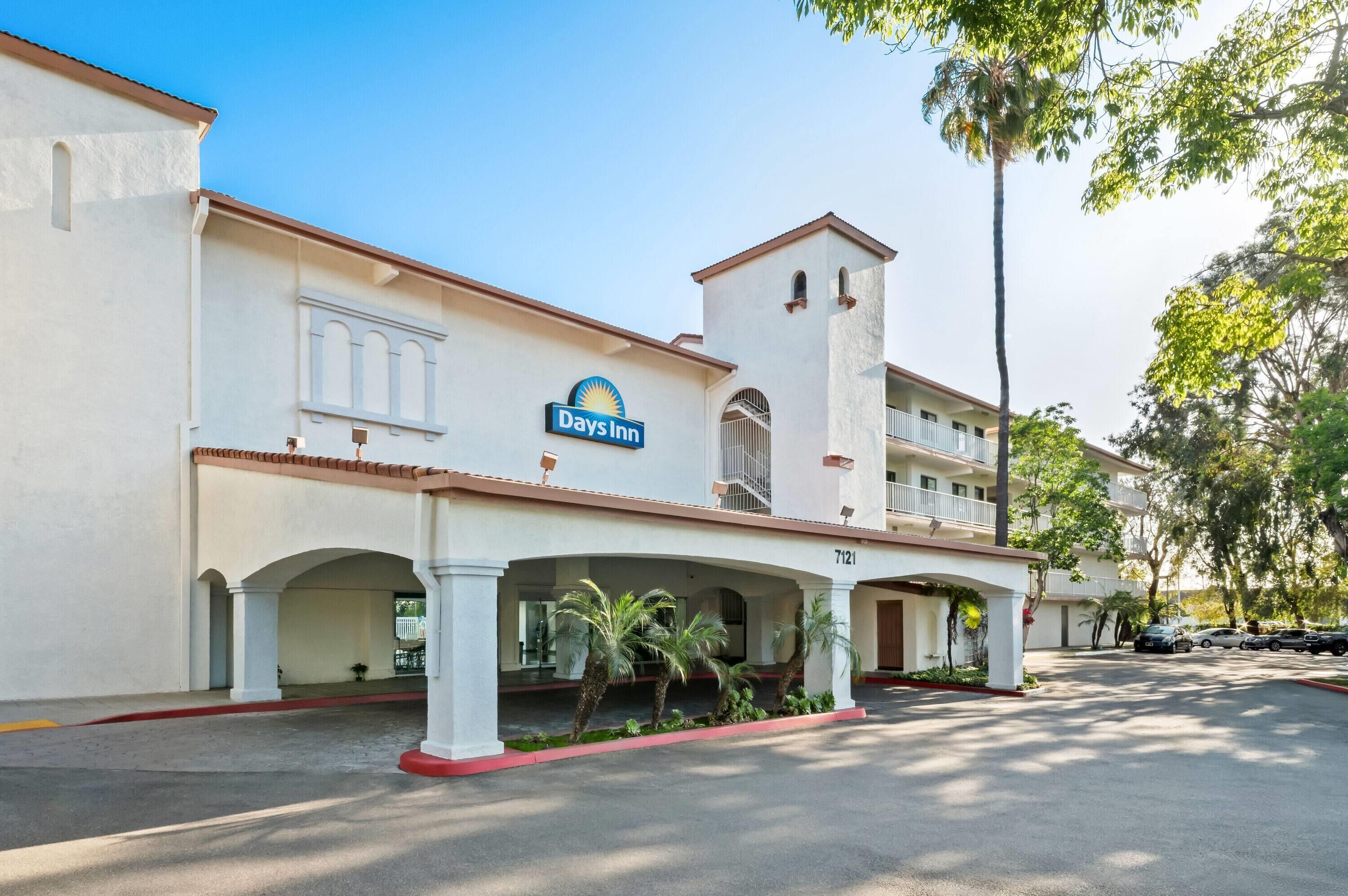 A Days Inn with a white facade, arched entrance, and a sign above the entrance.