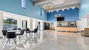 Een ruime lobby met een modern design, met een grote zithoek, een kitchenette en een aan de muur bevestigde televisie.
