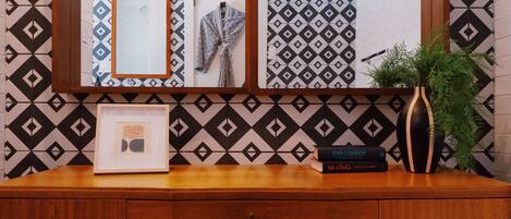 A wooden dresser with a framed picture, a potted plant, and two books.