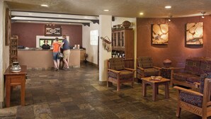 A lobby with a reception desk, patterned chairs, and artwork on the walls.