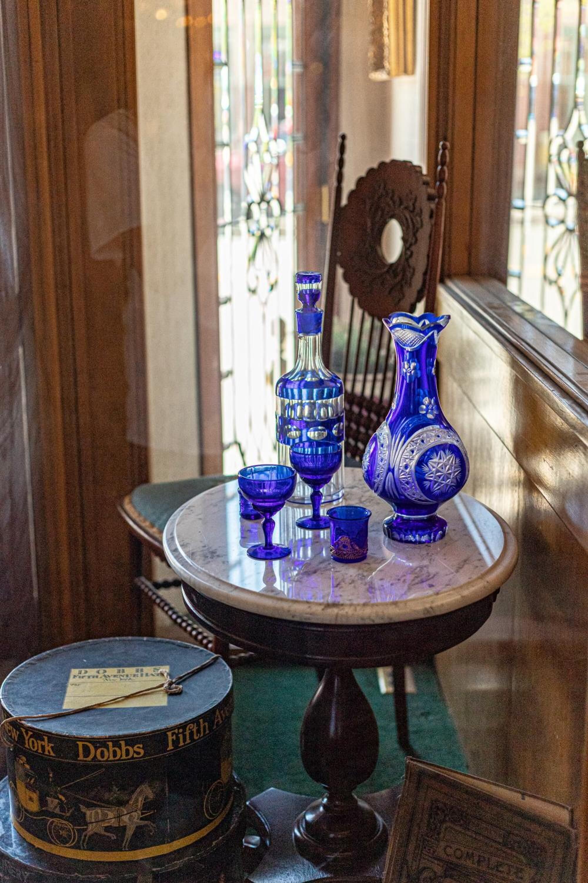 Una mesa con cristalería azul y un teléfono antiguo.