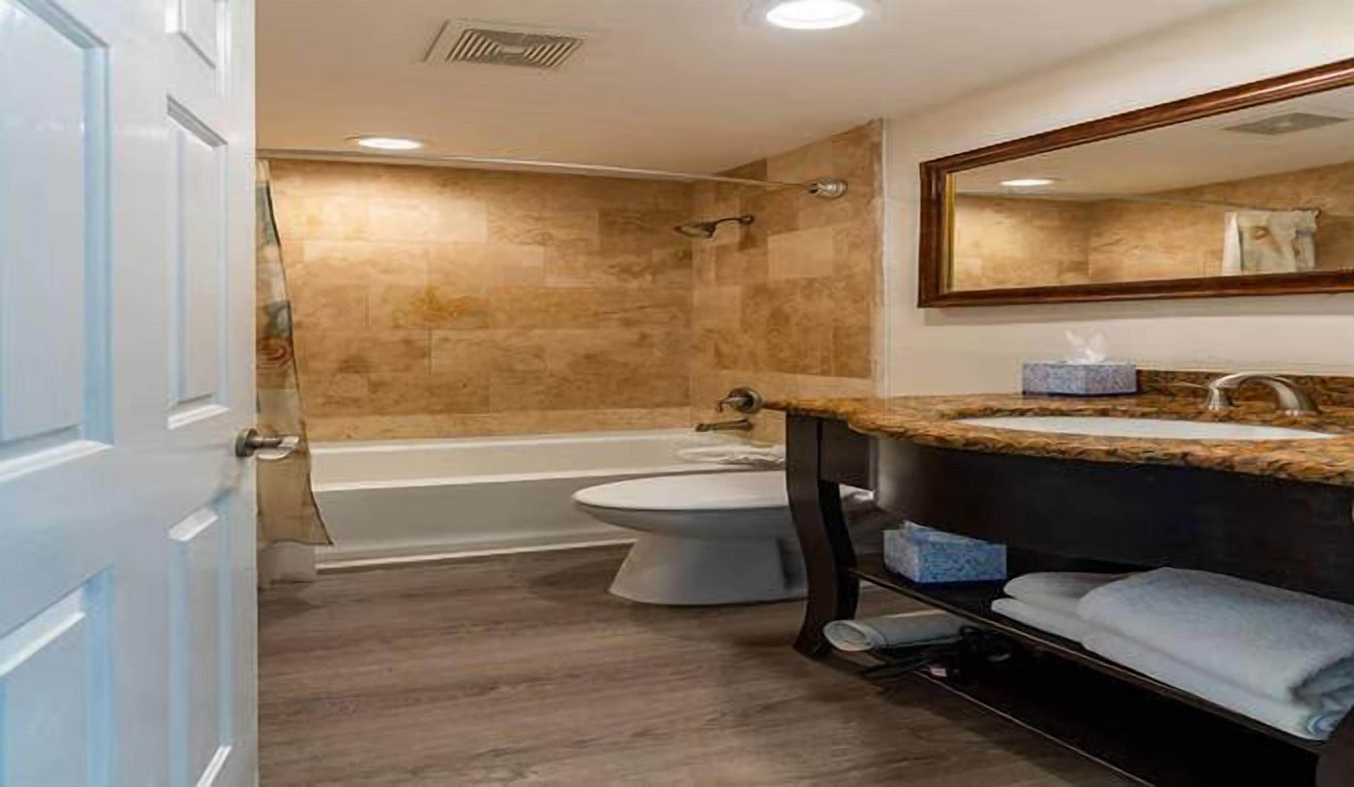 A bathroom with a bathtub, toilet, and sink.