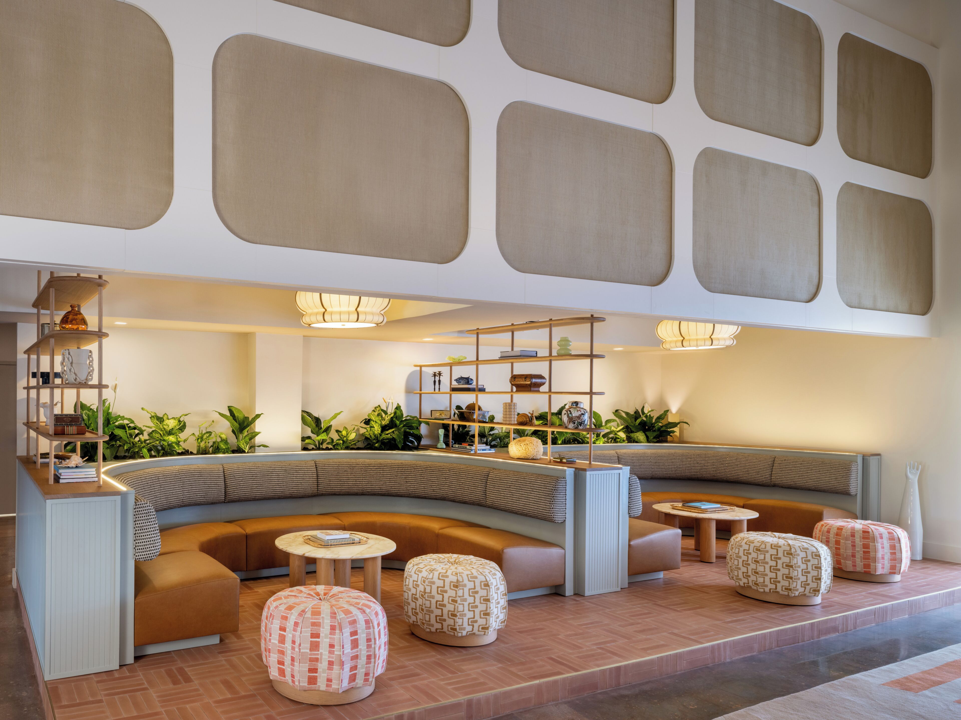 A modern lounge area with seating, tables, and decorative plants.