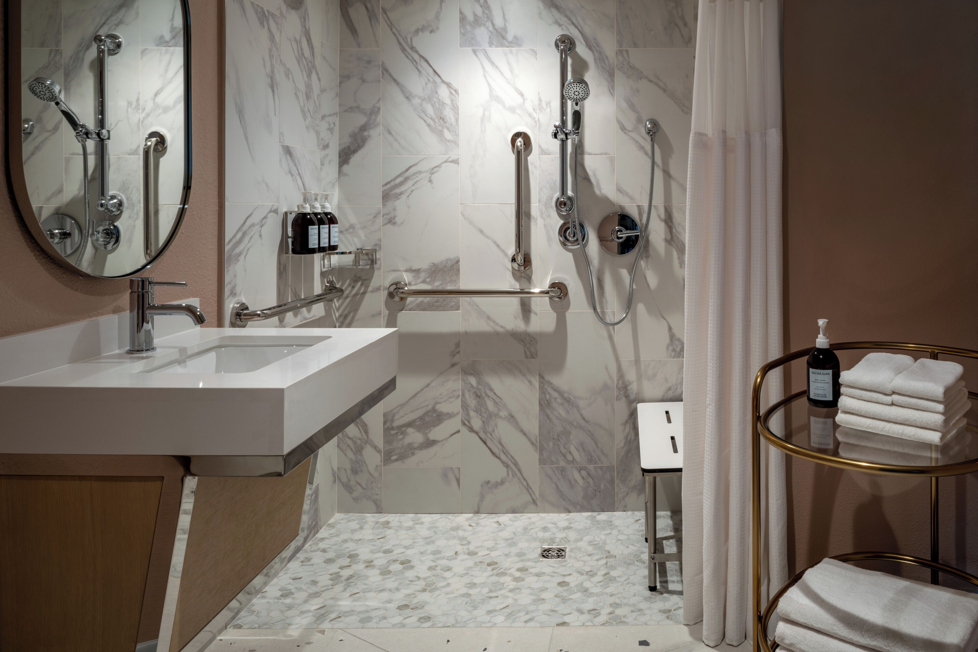 Un baño moderno con lavabo, espejo, ducha e inodoro.