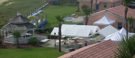 Un resort con piscina, vista a la playa y zona de comedor al aire libre.