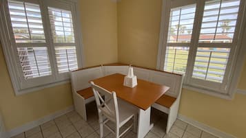 A corner dining area with a wooden table and white bench seating.
