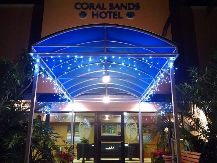 Indgangen til Coral Sands Hotel med overdækning og dekorative lyskæder.