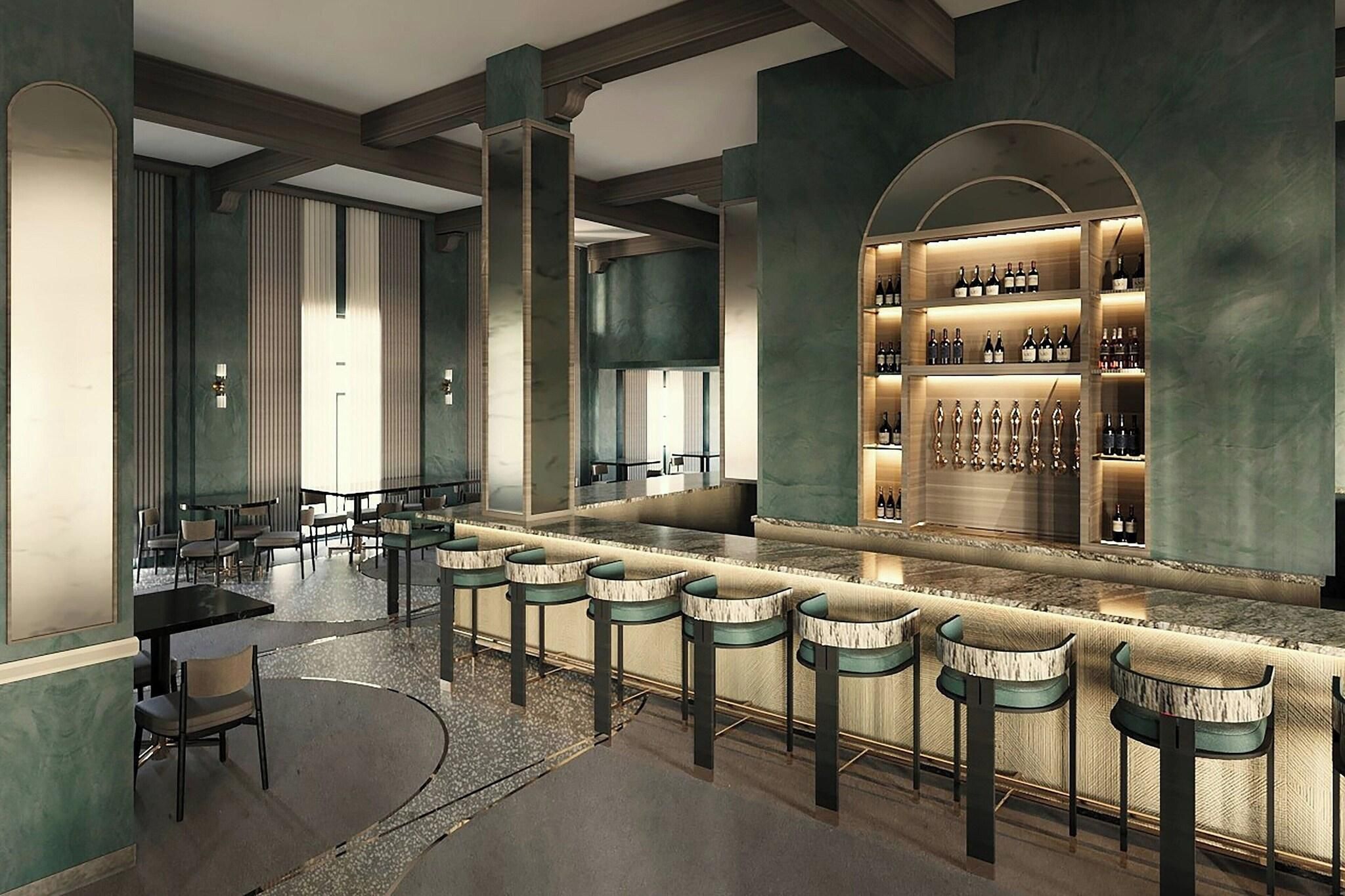 A bar area with a long counter, multiple stools, and a wine display.