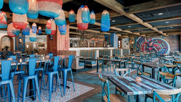 A restaurant with blue chairs, wooden tables, and hanging blue and red lanterns. - Westgate Towers Resort (Kissimmee)