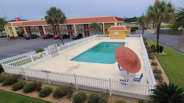 A hotel with a swimming pool, a fenced deck, and a parking lot. - Red Roof Inn Tifton (Tifton)