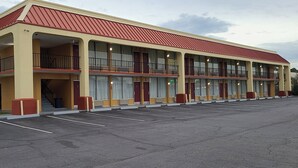 A multi-story motel with a red roof, large windows, and a parking lot. - Red Roof Inn Tifton (Tifton)