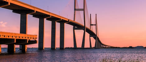 A large suspension bridge with multiple towers and cables, spanning over a body of water.