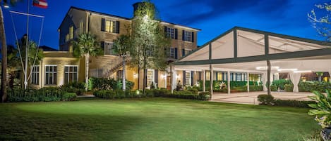 A two-story hotel with a covered outdoor area and a well-maintained lawn.