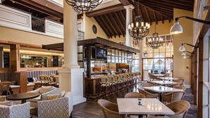 A spacious restaurant with high ceilings, wooden beams, and a variety of seating including booths and tables. - The King and Prince Beach & Golf Resort (St. Simons Island)