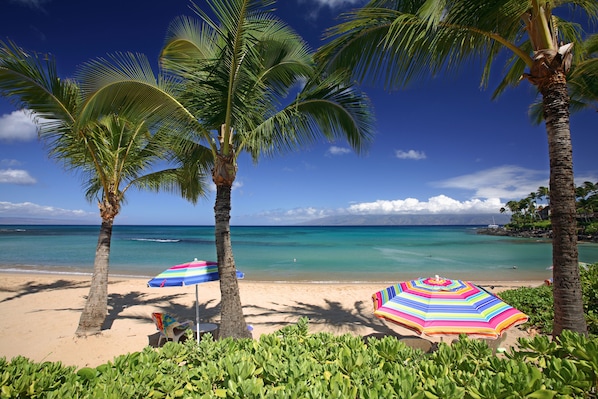 On the beach, white sand, sun-loungers, beach towels