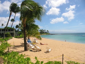 On the beach, white sand, sun loungers, beach towels