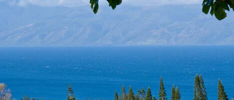 A golf course with a view of the ocean and mountains.