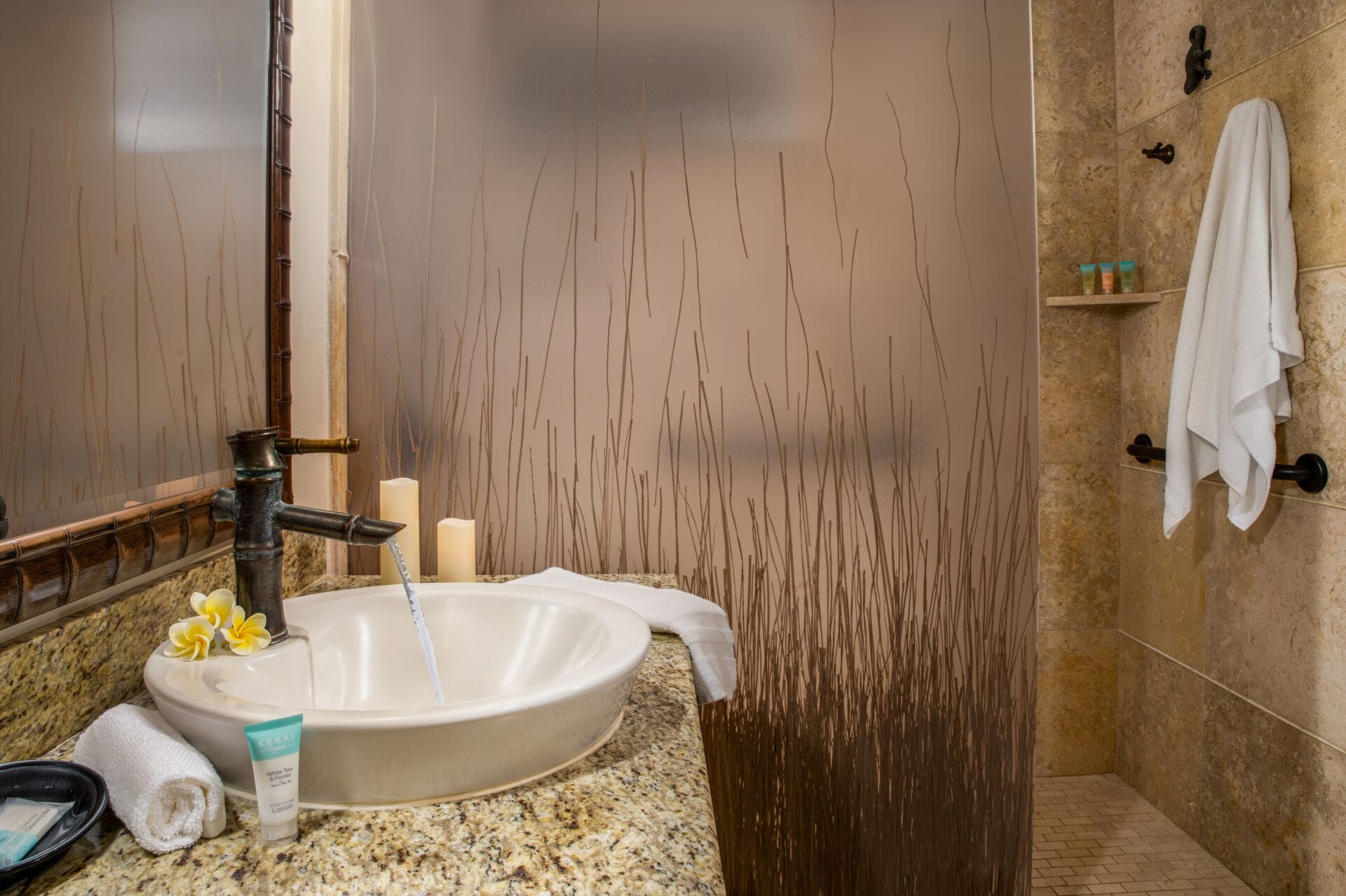 A bathroom with a large sink, a mirror, a towel rack, and a shower area.