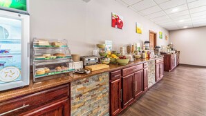 A breakfast bar with a refrigerator, toaster, and various food items.