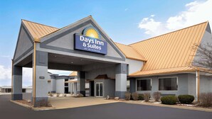 En Days Inn & Suites-byggnad med en modern design, kännetecknad av en stor skylt, en överbyggd entré och en parkeringsplats.