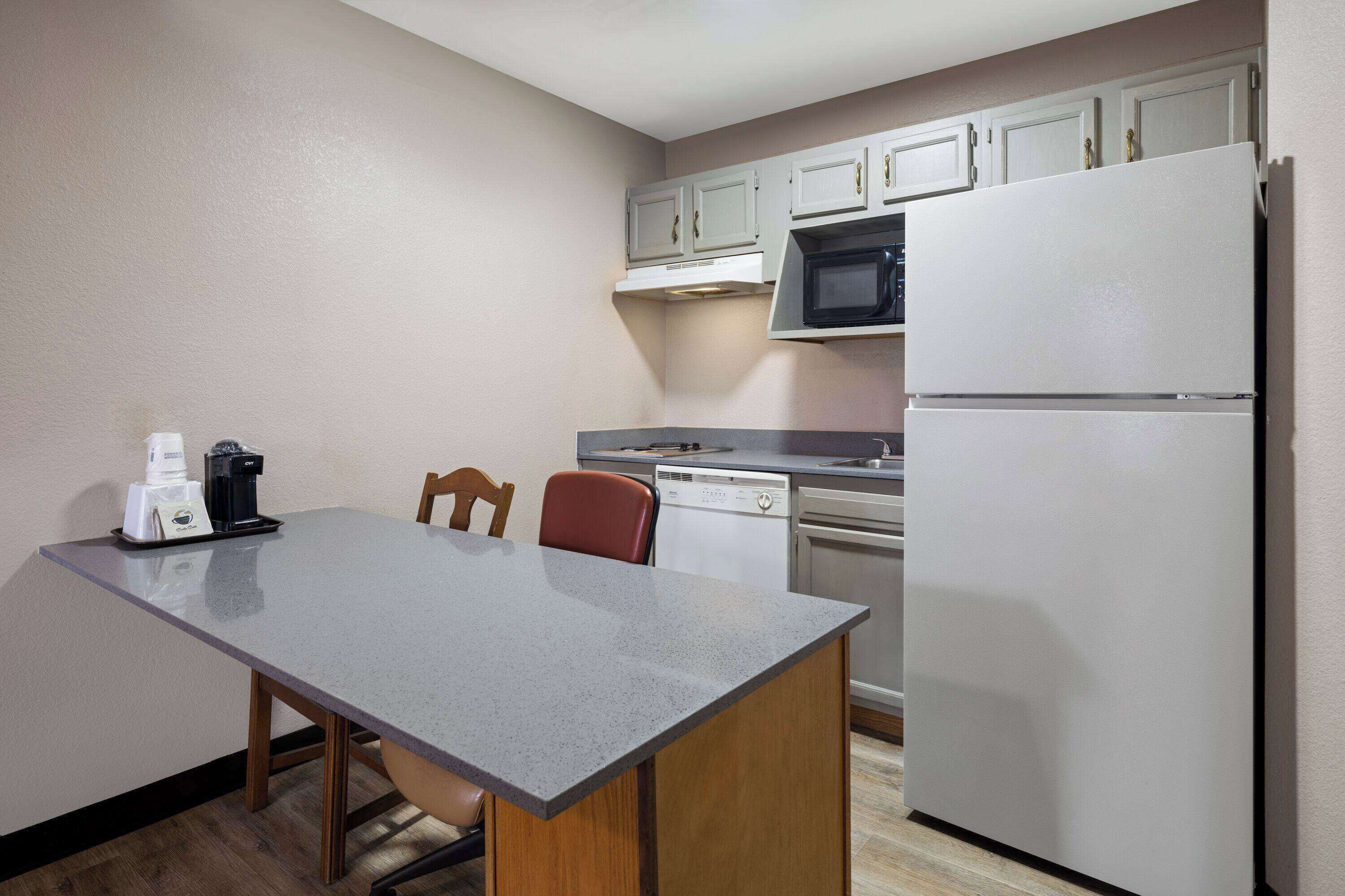 A compact kitchen with a microwave, dishwasher, and refrigerator.