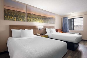 A hotel room with two beds, a large window with curtains, and a wall-mounted artwork of sunflowers. - Days Inn & Suites by Wyndham Kokomo (Kokomo)