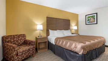 Een hotelkamer met een bed, een slaapbank, twee nachtkastjes met lampen en een lijst met een afbeelding aan de muur.