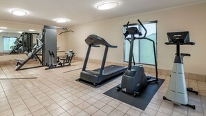 A gym with treadmills, elliptical machines, and a weight machine. - Quality Inn Creston (Creston)