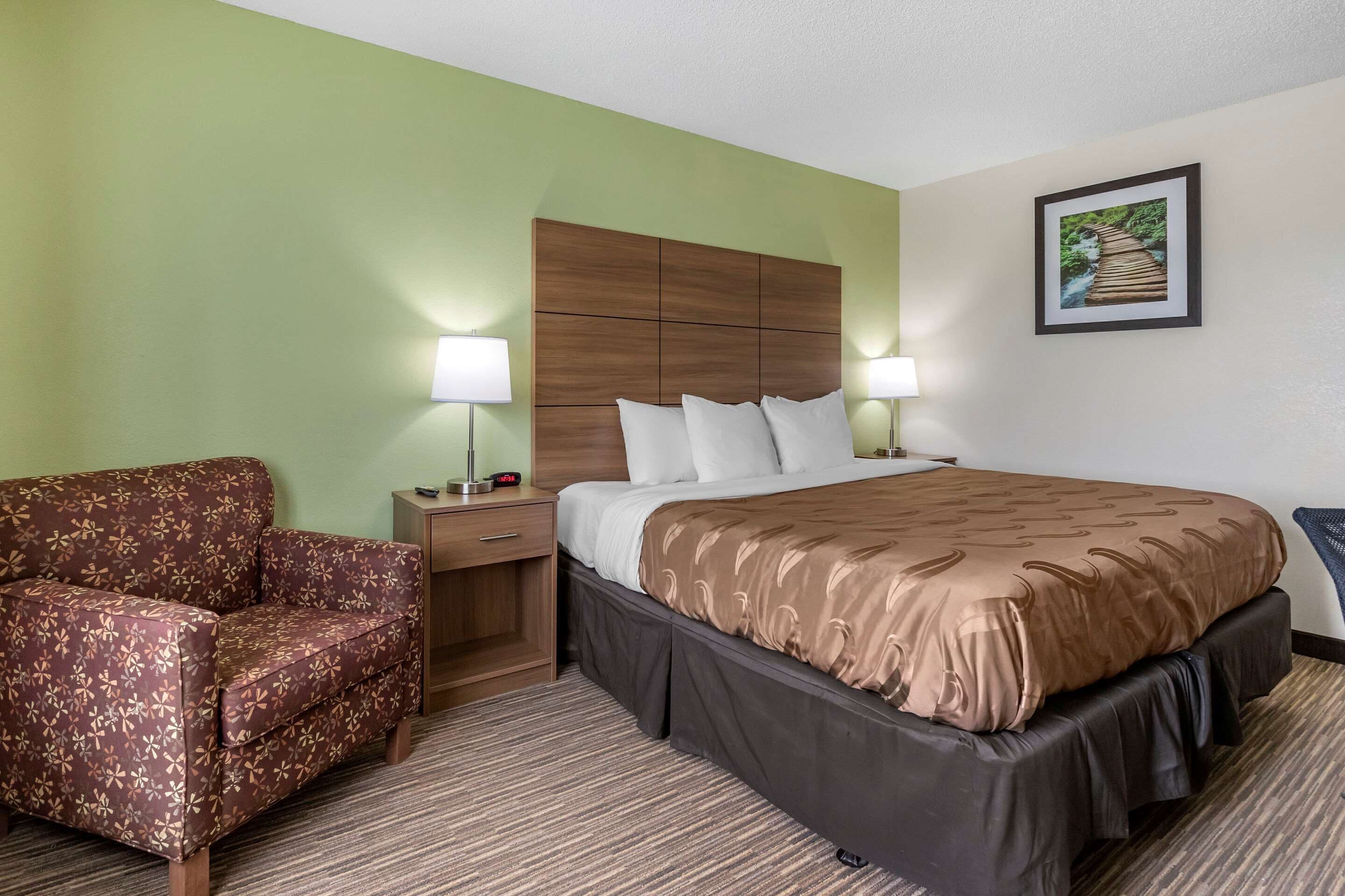 Een hotelkamer met een bed, een slaapbank, een nachtkastje en een aan de muur hangend schilderij.