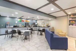 Una cafetería moderna con mostrador, zona de estar y sofás.
