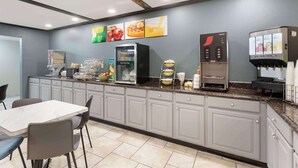 Een ontbijtbalk met een koelkast, koffieapparaat en drankenspender.