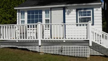 A two-story house with a white exterior, a front porch with a railing, and a garage door.