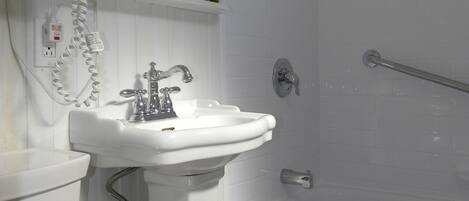 Une salle de bain avec un lavabo, un miroir et une douche.