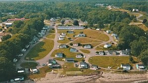 Vista aérea de una zona residencial con casas, carreteras y una playa.