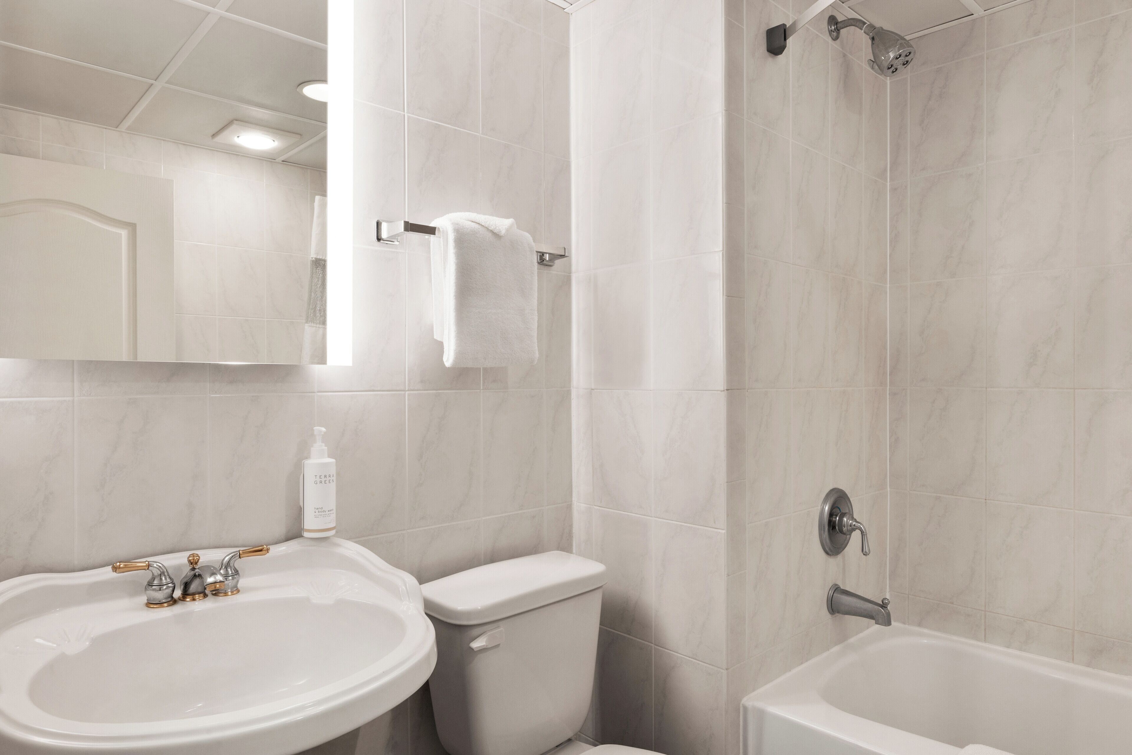 Een badkamer met een wastafel, toilet en bad.