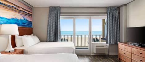 A hotel room with two beds, a TV, a painting, and a balcony with a view of the sea.