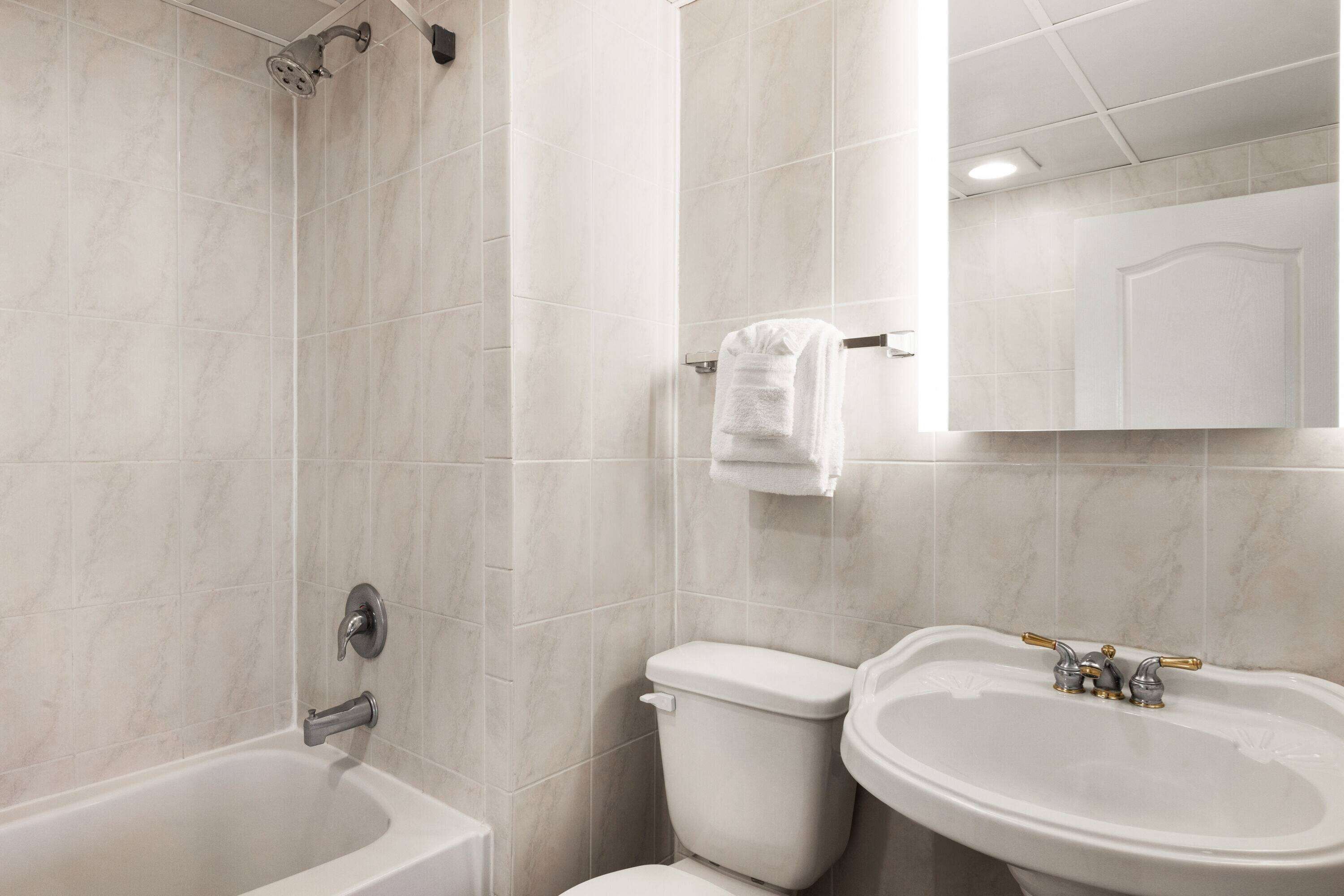 A bathroom with a bathtub, toilet, and sink.