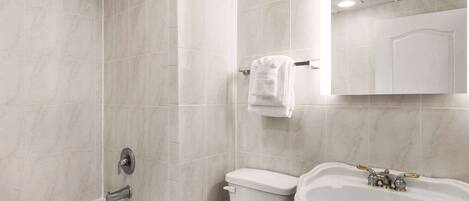 A bathroom with a bathtub, toilet, and sink.