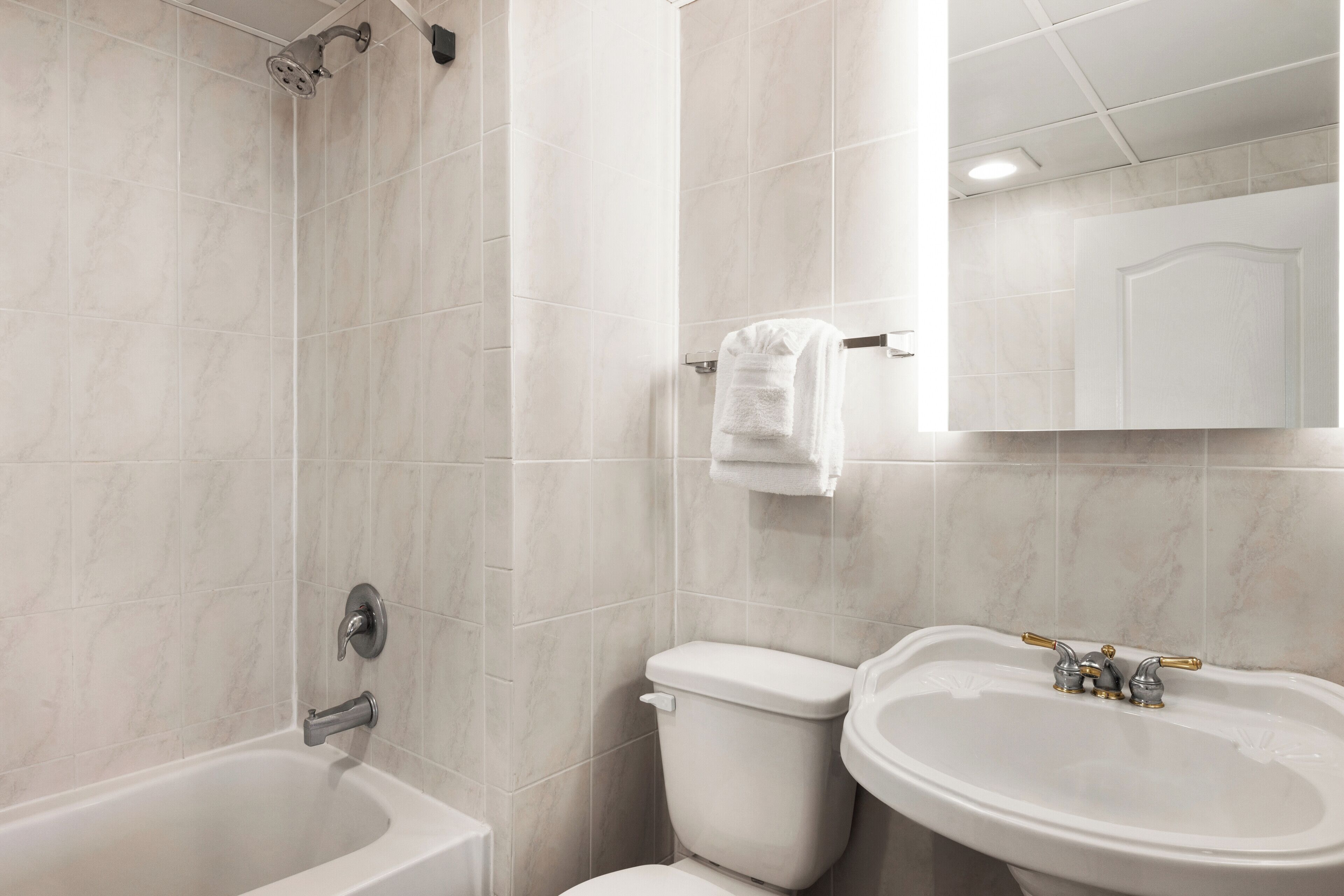 A bathroom with a bathtub, toilet, and sink.