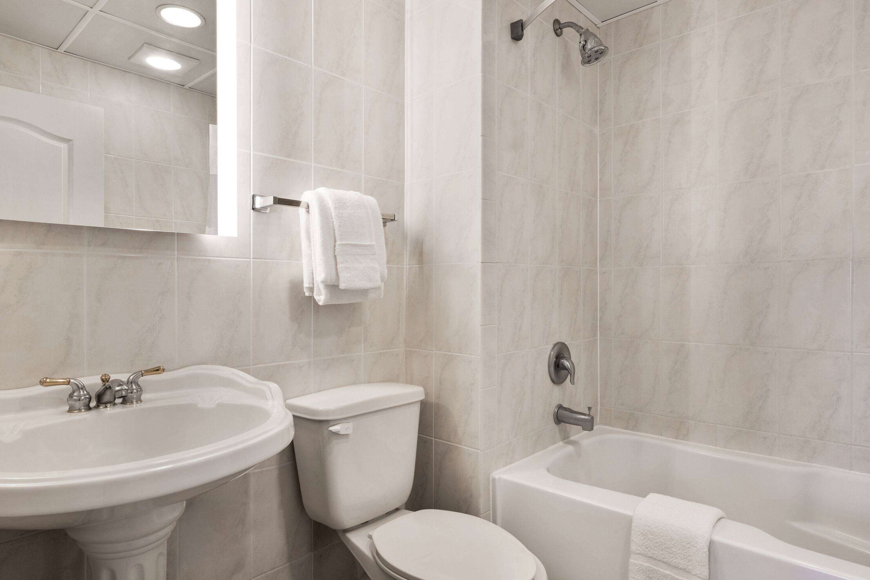 Een badkamer met een wastafel, toilet en bad.