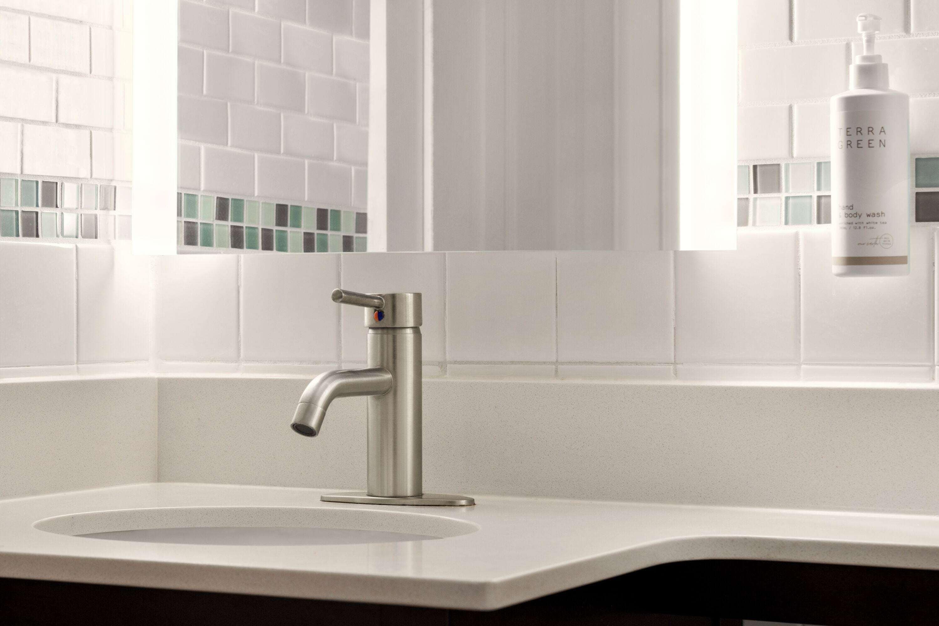 A modern bathroom with a sleek, metallic faucet, a white sink, and a window with a view of the city.