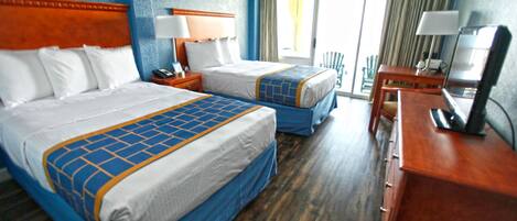 A hotel room with two beds, a desk, a chair, and a TV.