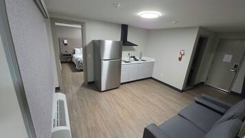 Un espacio habitable compacto con kitchenette, sofá y cama.